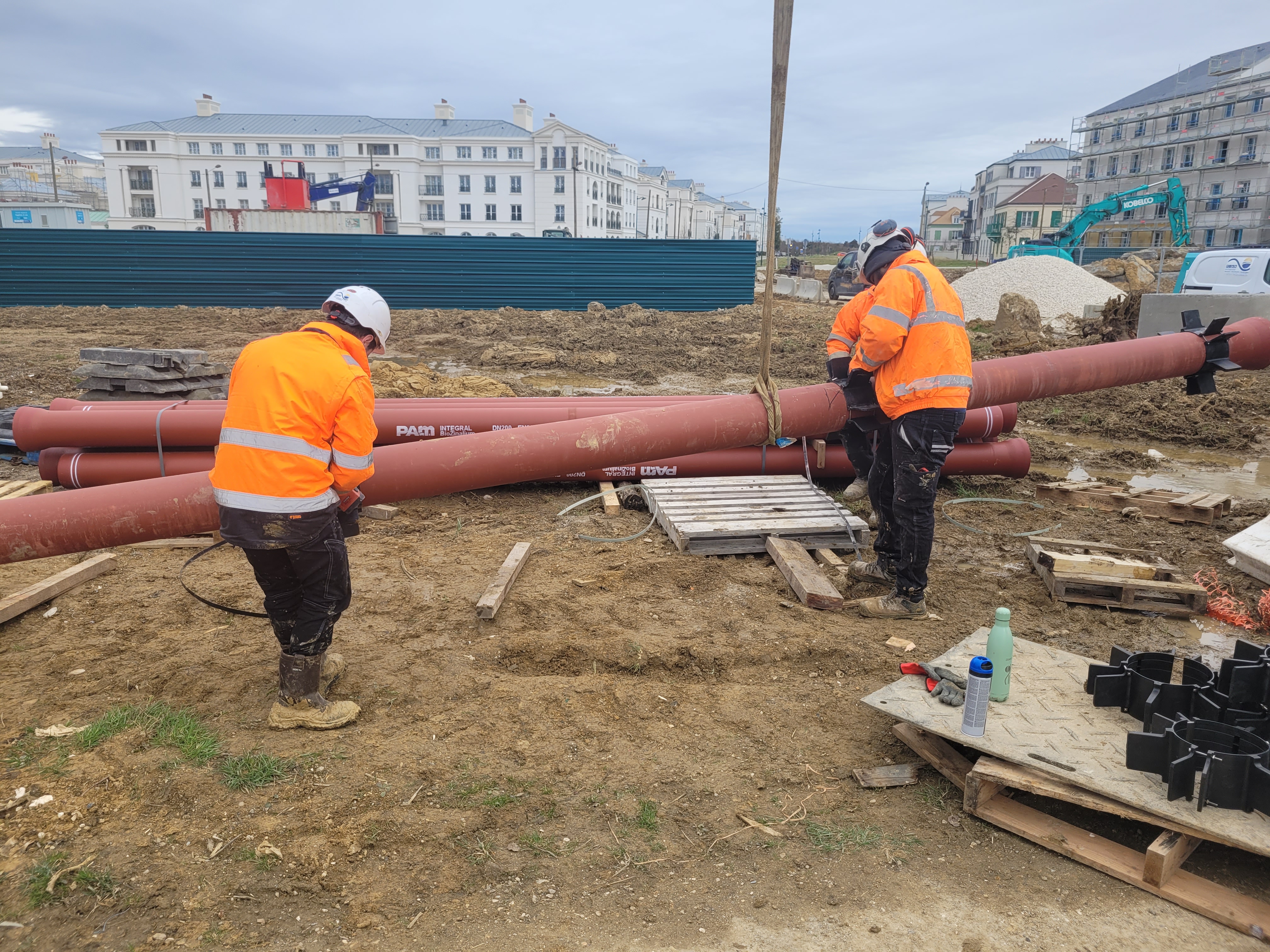 Équipe réalisant l'assemblage d'une canalisation sur un chantier d'assainissement