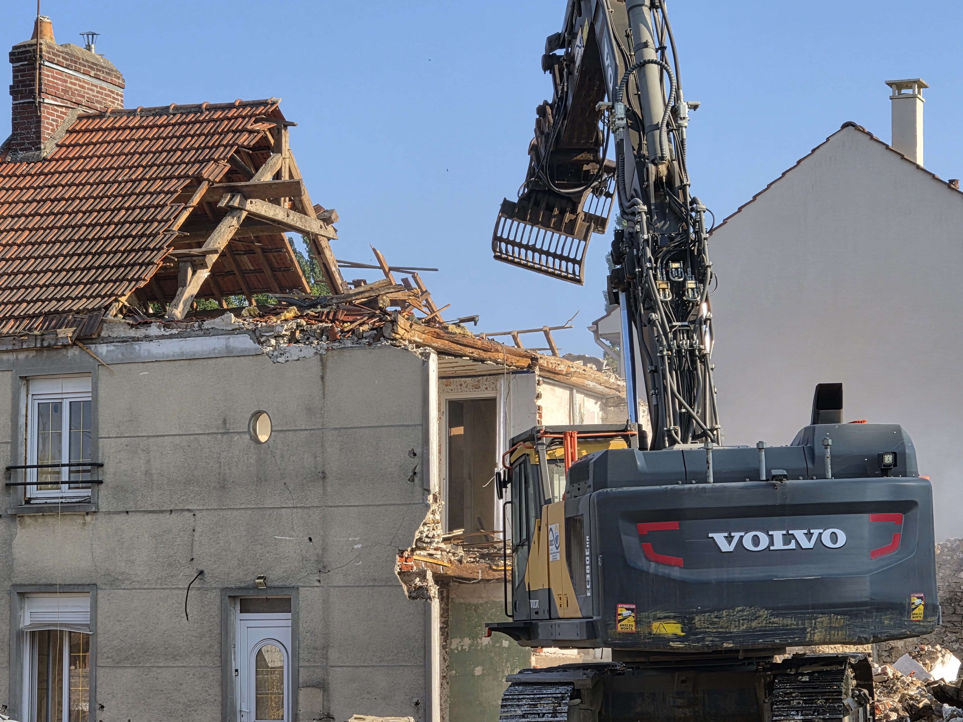 Pelle Volvo intervenant sur une maison en cours de déconstruction