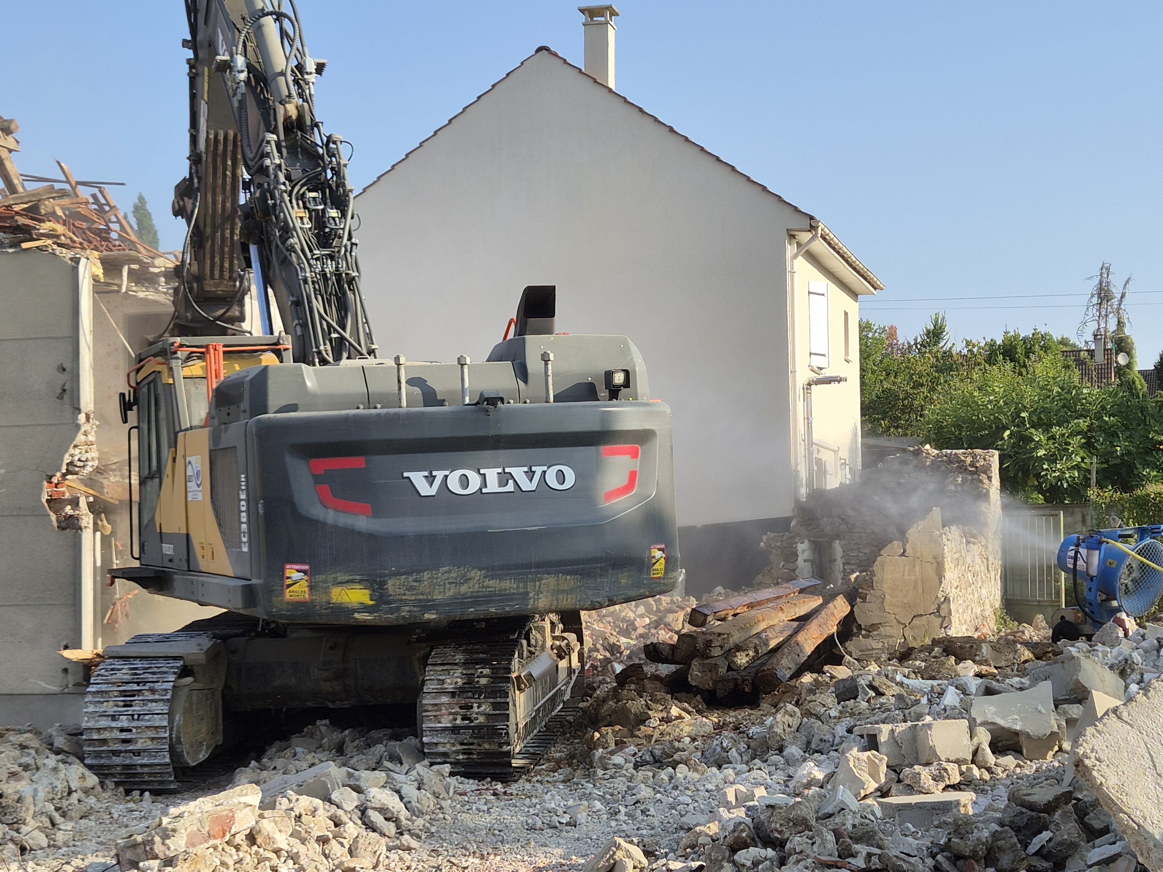Pelle Volvo et brumisation sur un chantier de déconstruction